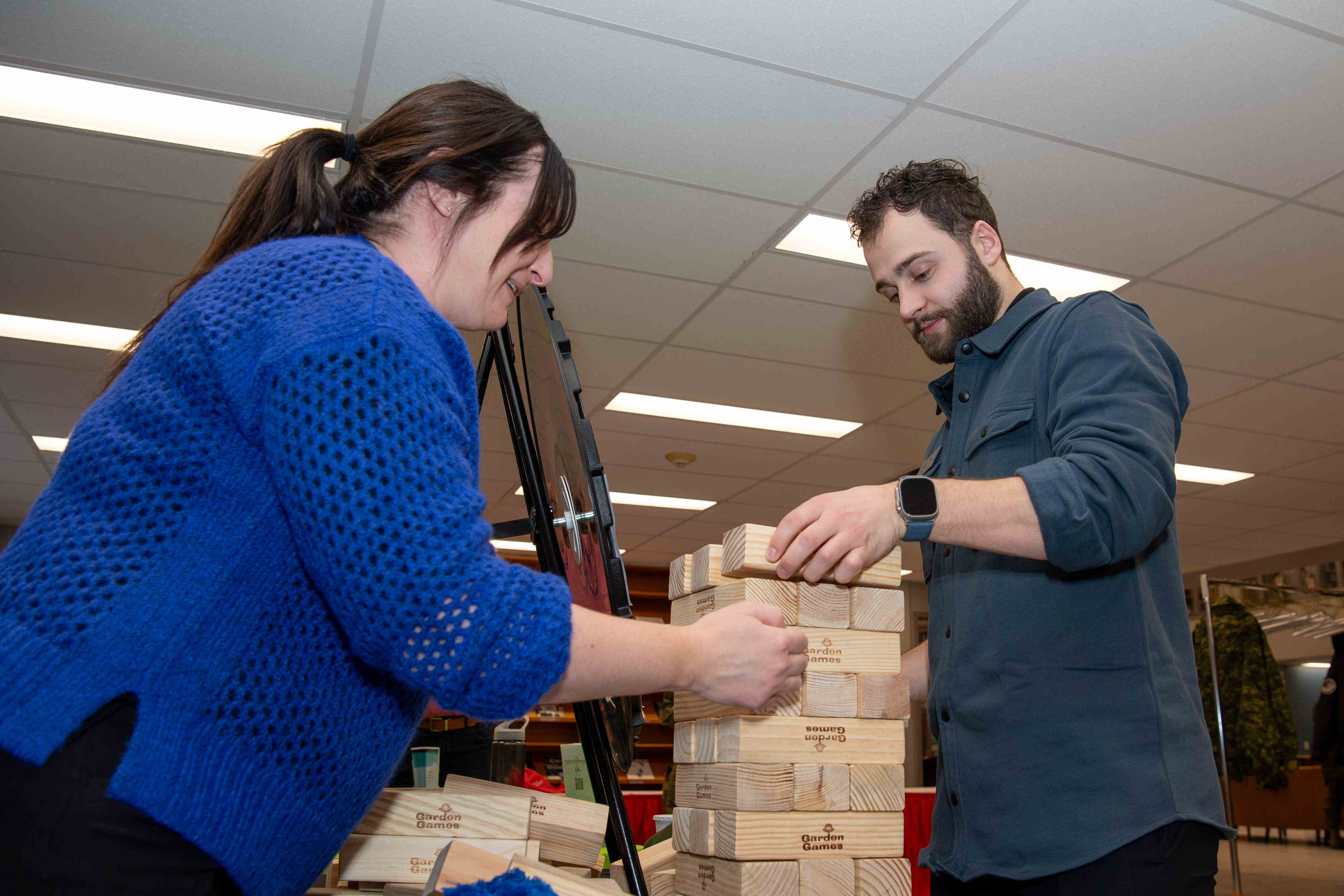 Two people rebuilding the Jenga tower