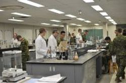 Technologue en chimie aidant les cadets dans la première année du laboratoire de chimie