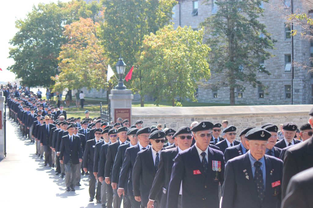 Procession of ex-cadets marching thru the old gate of RMC towards the memorial Arch.