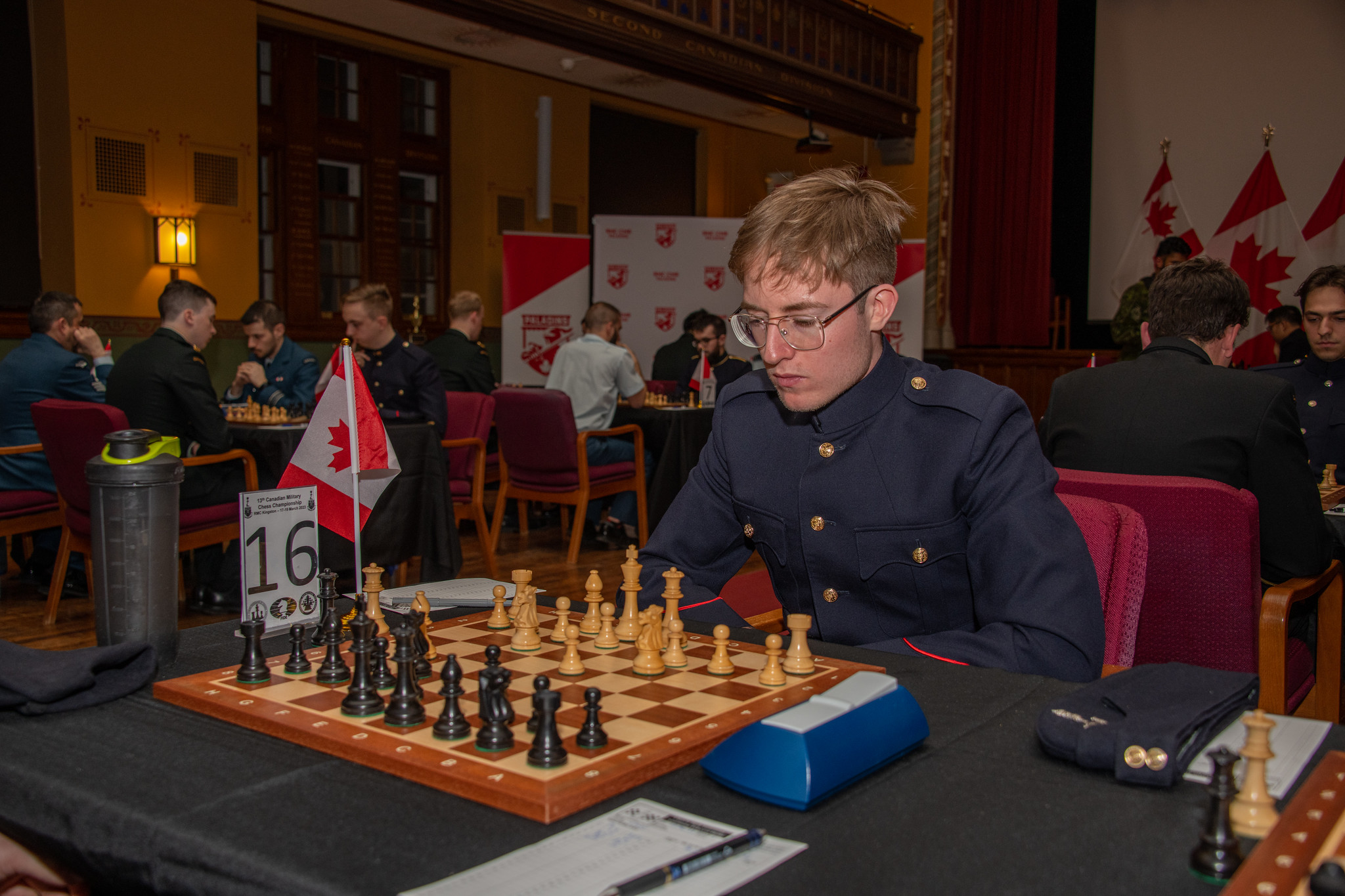 Un aspm/élof de première année joue aux échecs lors du Championnat canadien d'échecs militaire dans le bâtiment historique Currie, sur le campus.