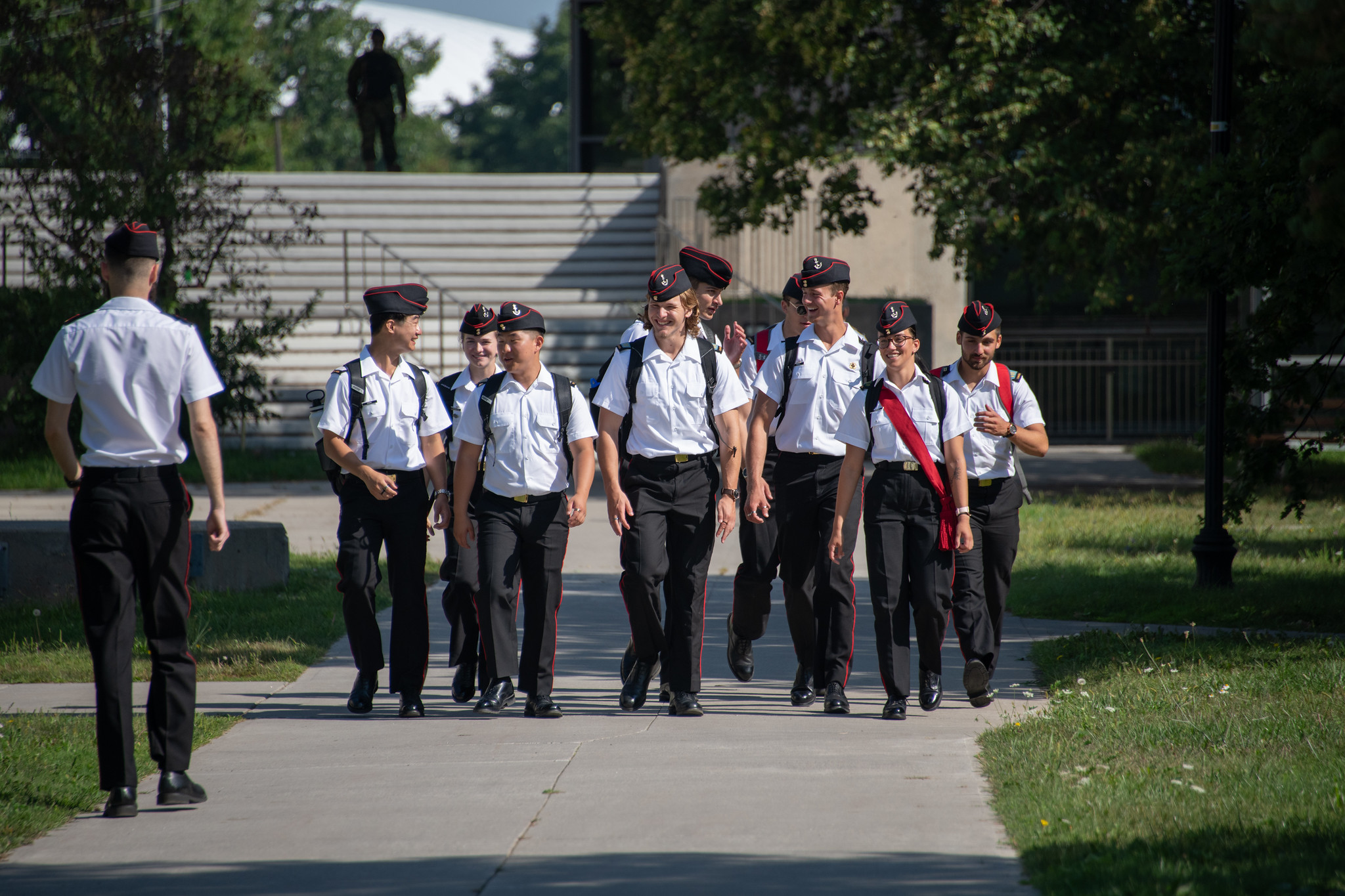 Neuf aspm/élof en uniforme marchent sur le campus entre les classes.