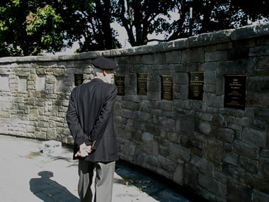 Un ancien élève-officier, membre de la Vieille Brigade, lisant des plaques de bronze sur le Mur