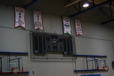 Scoreboard in SAM gymnasium with basketball awards banners