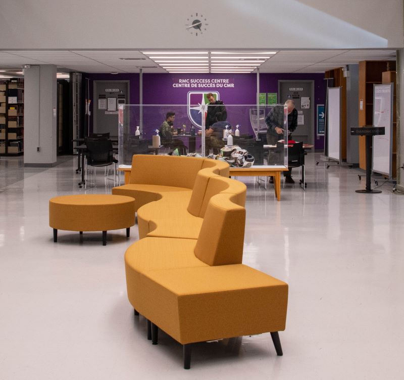 The inside of Massey Library. Includes couches, desks, students, and the RMC Success Centre purple wall.
