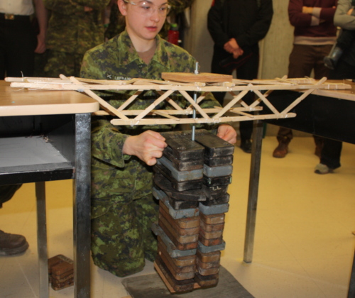 Second year student loads a popsicle bridge with weights 
